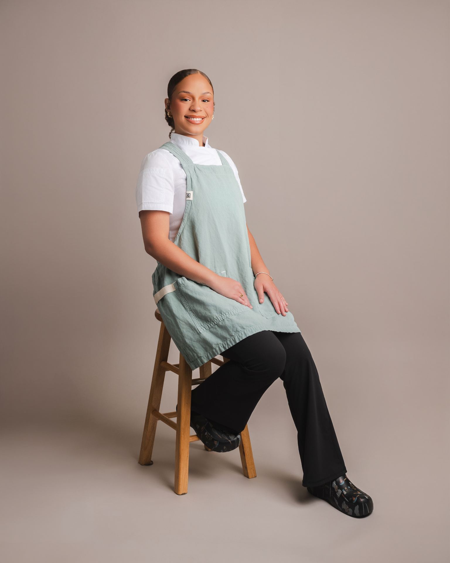 Chef Saiya seated in her kitchen apron